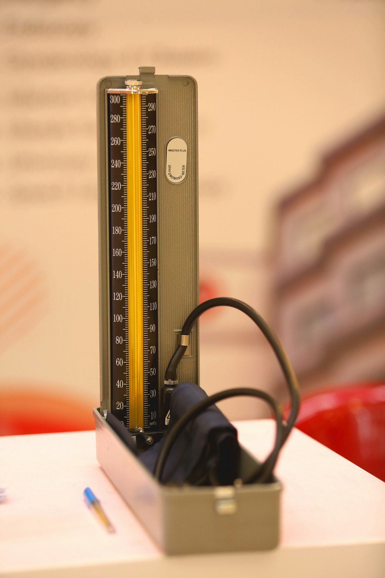 A mercury blood pressure monitor standing open on a clinic desk.